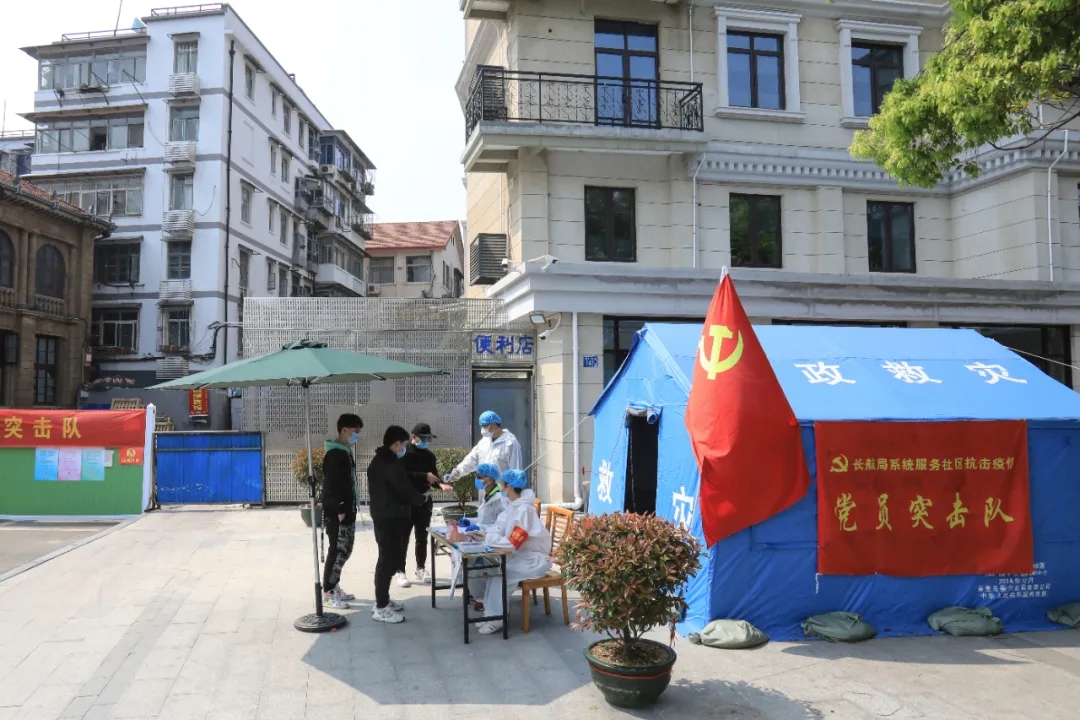 黨員突擊隊在小區(qū)防控點為出入群眾測量體溫，記錄信息。
